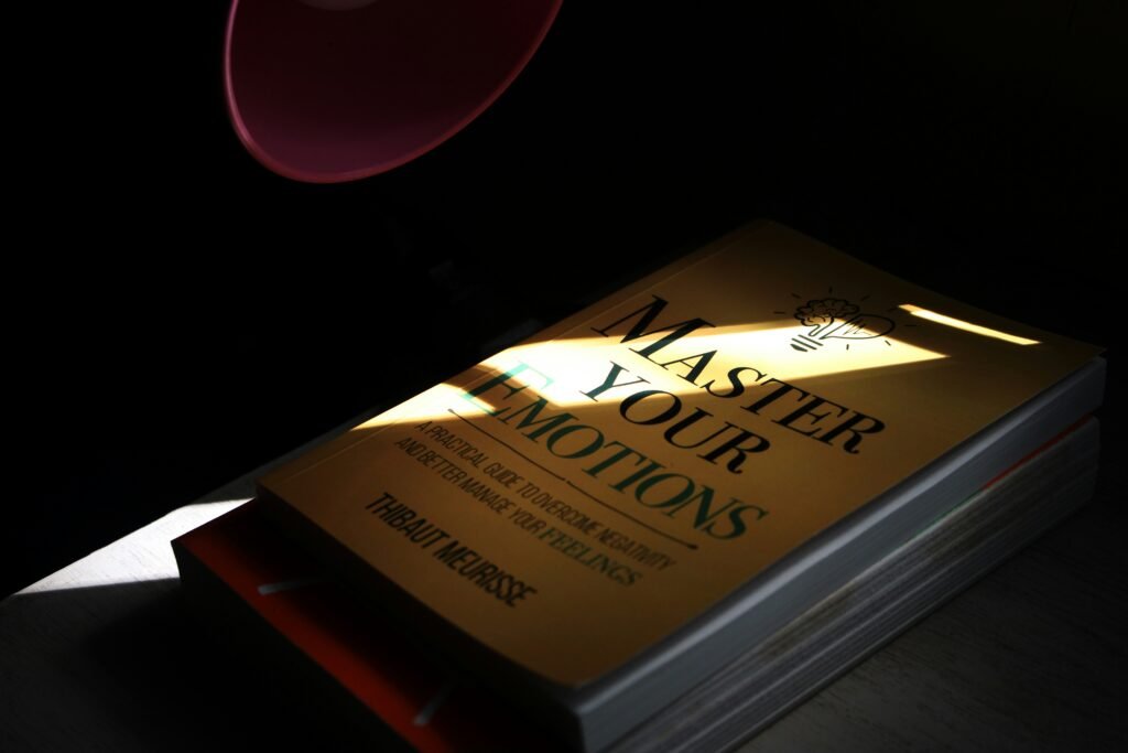 Book titled master your emotions under a lamp.